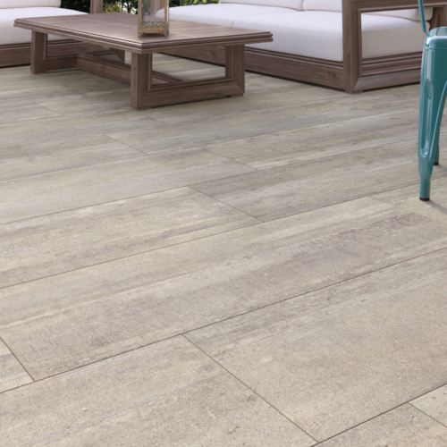 Außenbereich mit hellen Fliesen, Holzcouch, weißen Kissen, Holztisch, türkisfarbenem Stuhl