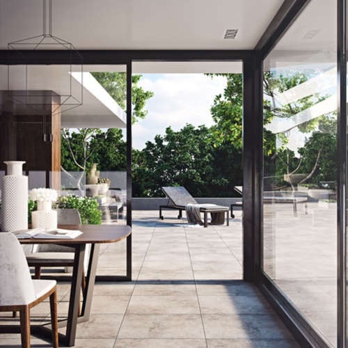 Moderner Innenraum mit Glaswänden, Esstisch, großer Terrasse und Liegestühlen.